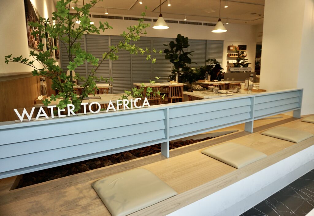 微風廣場成真咖啡 WATER TO AFRICA 公益主牆與大理石桌區