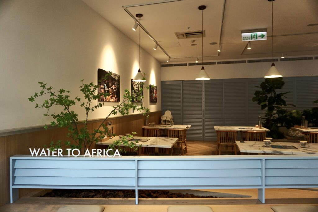 微風廣場成真咖啡 WATER TO AFRICA 公益主牆與大理石桌區