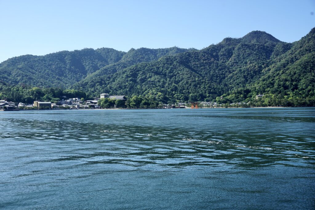 廣島宮島渡輪上遠望嚴島山林與海上小小紅色大鳥居